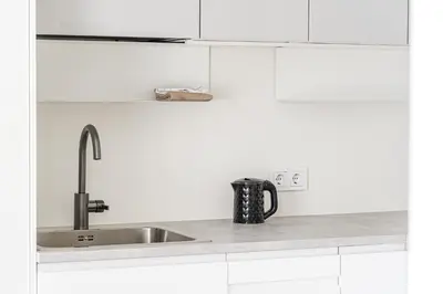 a kitchen with white cabinets and a sink at City center studio, parking, 16 in Vilnius