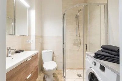 a bathroom with a toilet and a glass shower at City center studio, parking, 16 in Vilnius