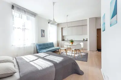 a bedroom with a bed and a table with chairs at Spacious Cozy Studio, 3A in Vilnius