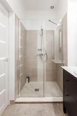 a shower with a glass door in a bathroom at Spacious Cozy Studio, 3A in Vilnius