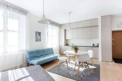 a living room with a blue couch and a table at Spacious Cozy Studio, 3A in Vilnius