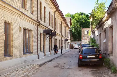 a man walking down a street next to a building at Spacious Cozy Studio, 3A in Vilnius