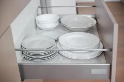 a group of plates and bowls in a cabinet at Spacious Cozy Studio, 3A in Vilnius