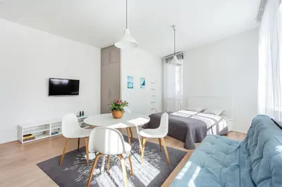 a living room with a table and chairs and a bed at Spacious Cozy Studio, 3A in Vilnius