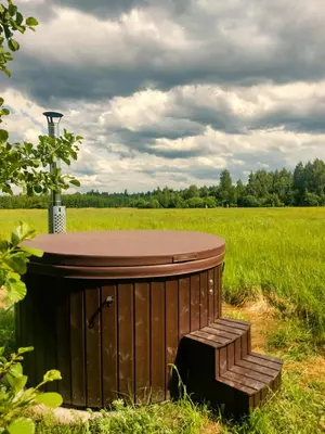 a wooden barrel with a bench in a field at Miško Pašvaistėje - poilsis gamtoje in Balneliškiai