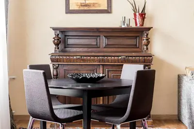 a dining room table with chairs and a piano at City Center apartment, 8 in Vilnius