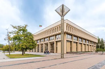 a large building with a flag on top of it at City Center apartment, 8 in Vilnius