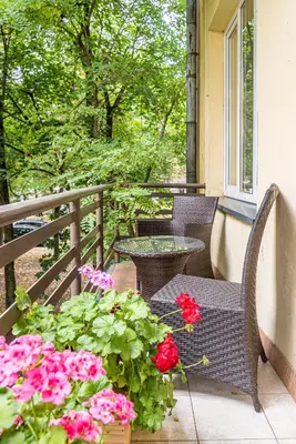 a table and chairs on a balcony with flowers at City Center apartment, 8 in Vilnius