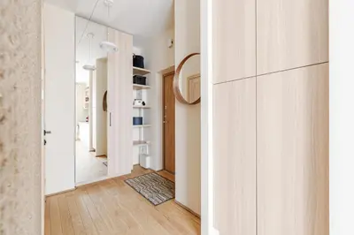 a hallway with white walls and a door with a mirror at City center, studio, 514 in Vilnius