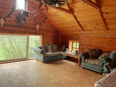 a living room with two couches in a log cabin at Sodyba Pas Juzi in Alanta