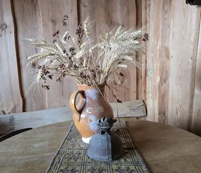 a vase sitting on a table with a plant in it at Sodyba Pas Juzi in Alanta