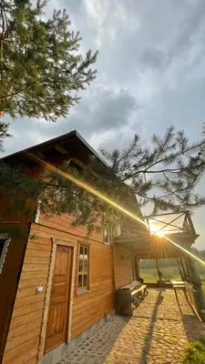a wooden house with the sun shining on it at Sodyba Pas Juzi in Alanta