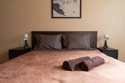 a bedroom with a bed with two towels on it at OZO Park city center in Vilnius