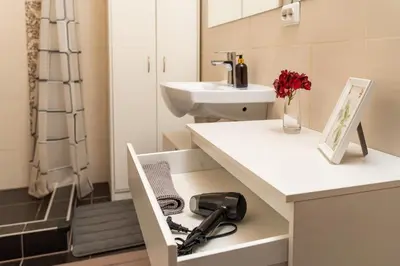 a bathroom with a sink and a white counter with a drawer at OZO Park city center in Vilnius