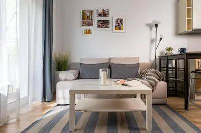 a living room with a couch and a table at OZO Park city center in Vilnius