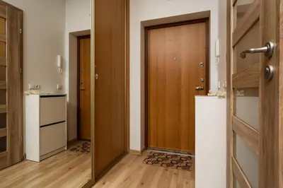 a hallway with a wooden door and wooden floors at OZO Park city center in Vilnius