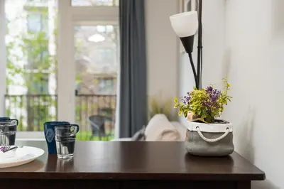 a table with a lamp and flowers on it at OZO Park city center in Vilnius