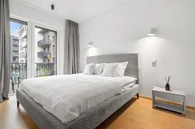 a white bedroom with a large bed and a window at City center, 91 with parking in Vilnius