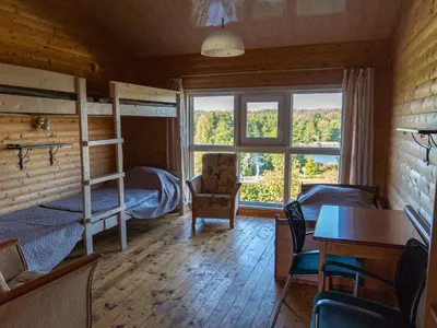 a room with bunk beds and a table and chairs at Sodyba Jums in Bijūnai