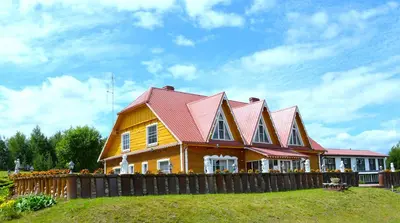 a house with a red roof on top of a yard at Sodyba Jums in Bijūnai