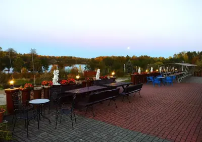 a patio with tables and chairs and a fountain at Sodyba Jums in Bijūnai