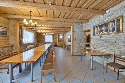a large dining room with wooden tables and chairs at Sodyba Jums in Bijūnai