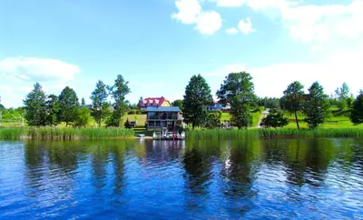 a house on the shore of a large lake at Sodyba Jums in Bijūnai