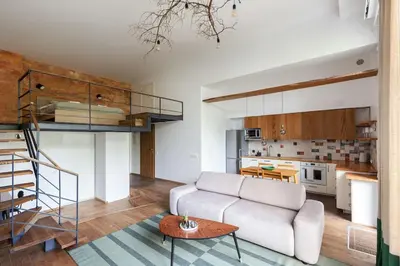 a living room with a couch and a loft at Cosy Loft with Terrace in Paupys by URBAN RENT in Vilnius