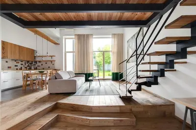a living room with a staircase leading to a kitchen at Cosy Loft with Terrace in Paupys by URBAN RENT in Vilnius