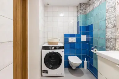 a bathroom with a washing machine and a toilet at Cosy Loft with Terrace in Paupys by URBAN RENT in Vilnius