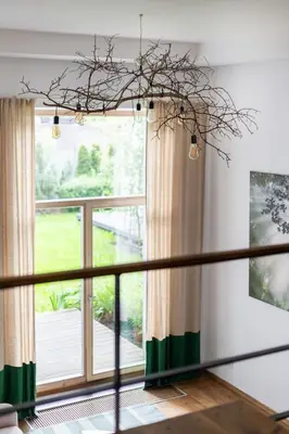 a living room with a large window and a branch at Cosy Loft with Terrace in Paupys by URBAN RENT in Vilnius