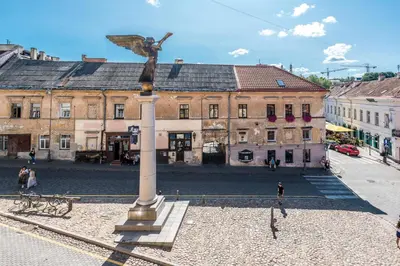 a statue of an angel on a pole in front of a building at Angel House Vilnius, 32 in Vilnius