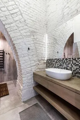 a bathroom with a sink and a brick wall at Old Brewery Loft in Paupys by Urban Rent in Vilnius