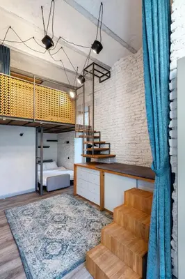 a loft apartment with a staircase and a bunk bed at Old Brewery Loft in Paupys by Urban Rent in Vilnius