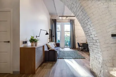 a living room with a couch and a brick wall at Old Brewery Loft in Paupys by Urban Rent in Vilnius