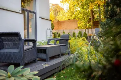 three wicker chairs sitting on a deck in a garden at Old Brewery Loft in Paupys by Urban Rent in Vilnius