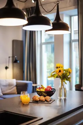 a table with a bowl of fruit and a vase of flowers at Old Brewery Loft in Paupys by Urban Rent in Vilnius