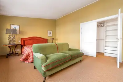 a bedroom with a green couch and a bed at City center, free parking, 4A in Vilnius