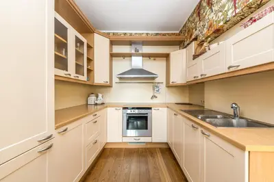 a kitchen with white cabinets and a sink at City center, free parking, 4A in Vilnius