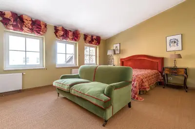 a bedroom with a green chair and a bed at City center, free parking, 4A in Vilnius