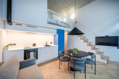a kitchen and living room with a table and chairs at Paupys Central Lofts by Reside Baltic in Vilnius