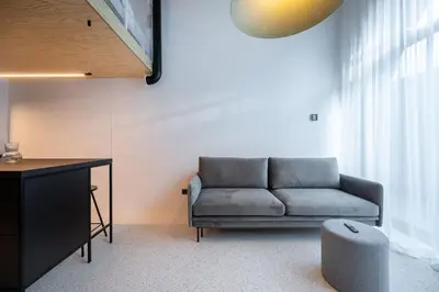 a living room with a couch and a desk at Paupys Central Lofts by Reside Baltic in Vilnius