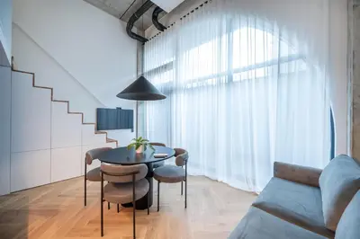 a living room with a table and chairs and a couch at Paupys Central Lofts by Reside Baltic in Vilnius