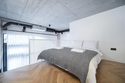 a bedroom with a bed and a wooden floor at Paupys Central Lofts by Reside Baltic in Vilnius