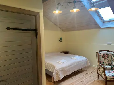 a bedroom with a bed and a window and a door at Ledainė in Naujasodis