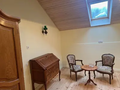 a room with two chairs and a table and a window at Ledainė in Naujasodis