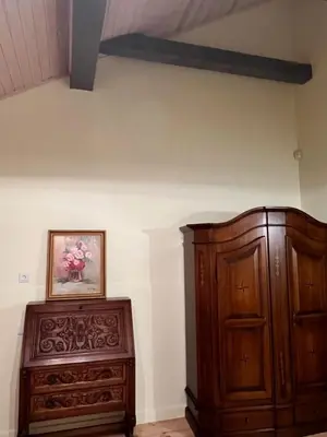 a bedroom with a wooden cabinet and a painting on the wall at Ledainė in Naujasodis