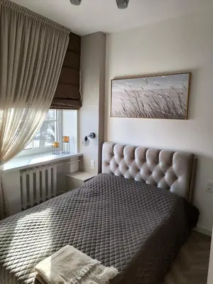 a bedroom with a large bed and a window at Jaukus butas Šiaulių centre in Šiauliai