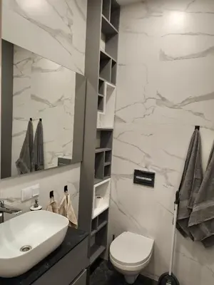 a bathroom with a white sink and a toilet at Jaukus butas Šiaulių centre in Šiauliai