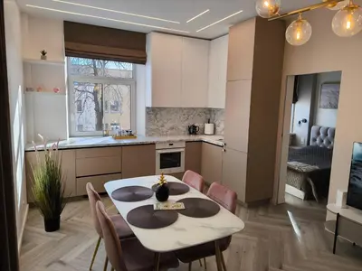 a kitchen and dining room with a table and chairs at Jaukus butas Šiaulių centre in Šiauliai